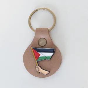 ميدالية مفاتيح يدوية من الجلد الطبيعي بتصميم يد تحمل علم فلسطين